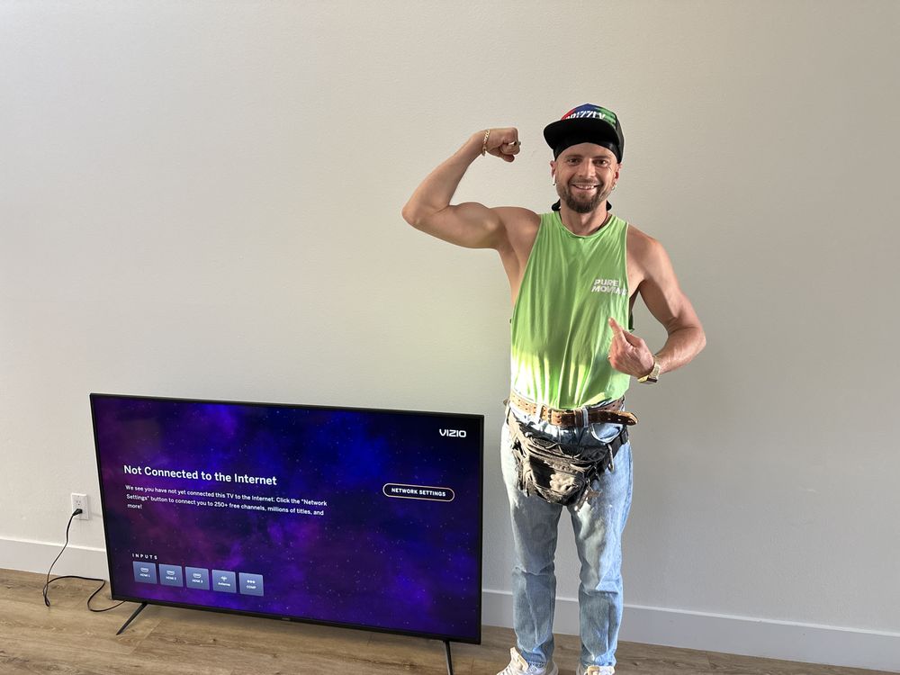 Pure Movers team member assisting with TV setup after a move
