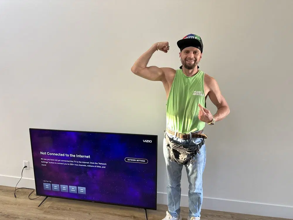 Pure Movers team member assisting with TV setup after a move