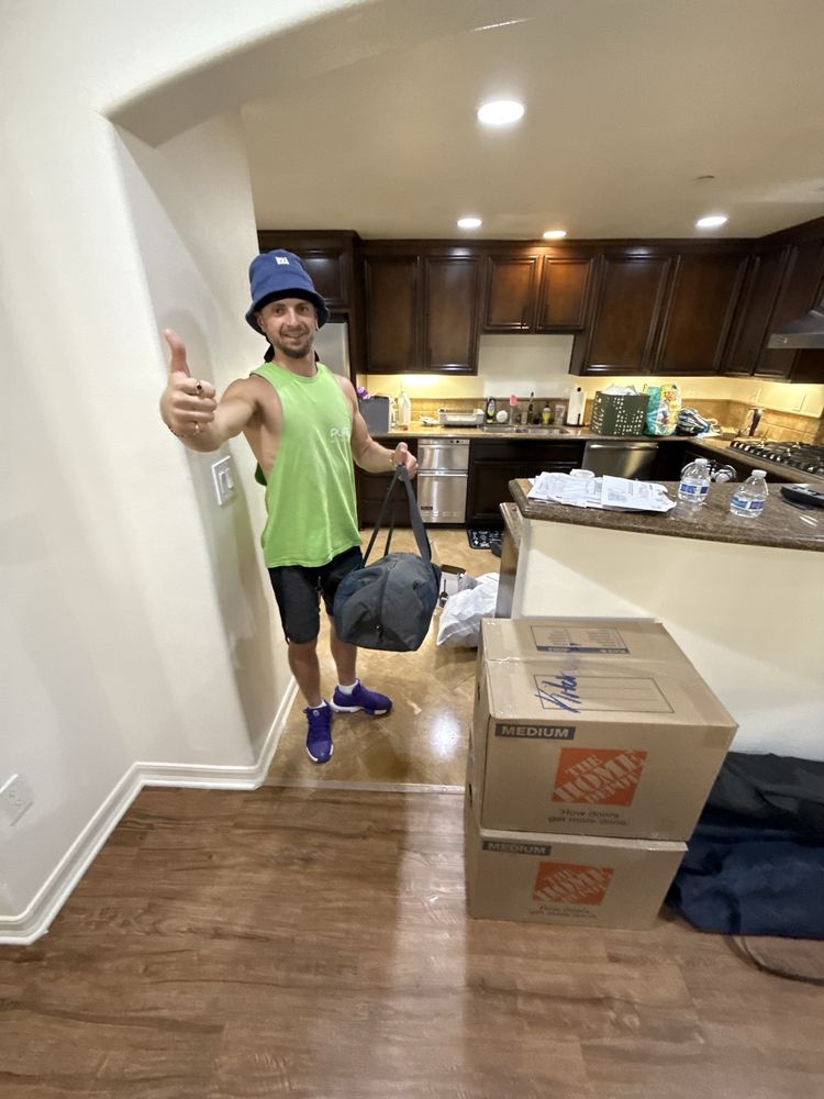 Pure Movers team member unpacking boxes inside a residential kitchen