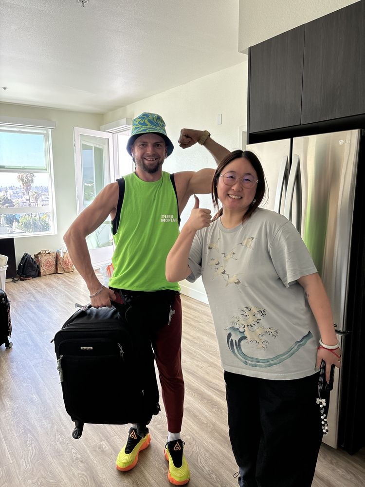Pure Movers employee assisting customer with luggage during apartment move