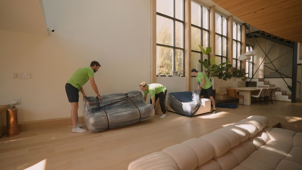 Pure Movers team wrapping furniture inside modern luxury home