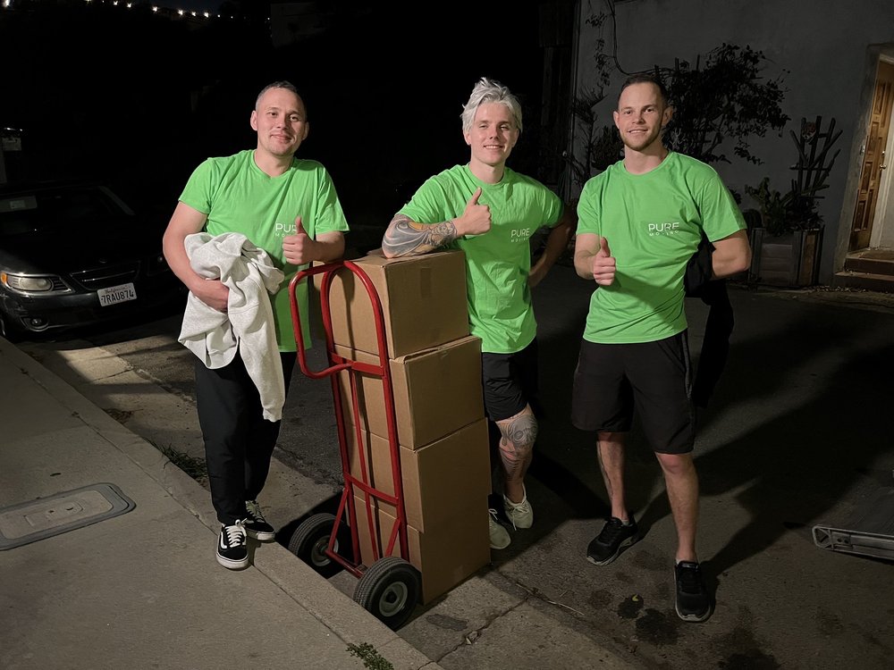 Residential mover carrying labeled moving boxes inside large home