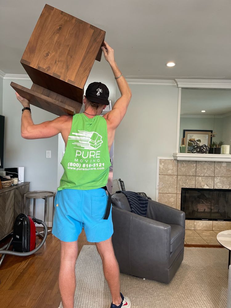 Professional mover safely carrying wooden furniture during move