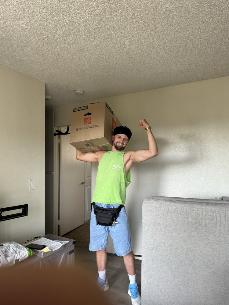 San Francisco mover carrying large moving box inside apartment