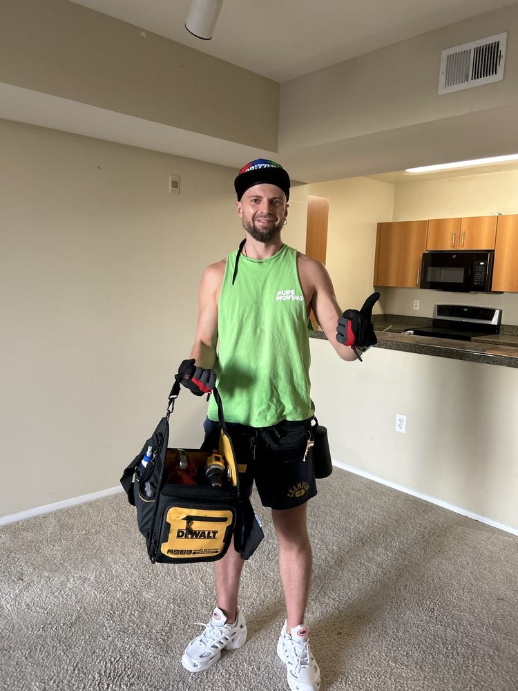 Mover carrying tool bag inside empty apartment for move-in setup and assembly