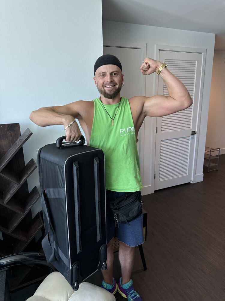 Strong mover holding large suitcase during residential moving job