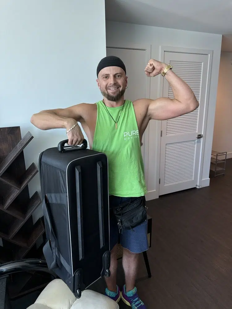 Strong mover holding large suitcase during residential moving job