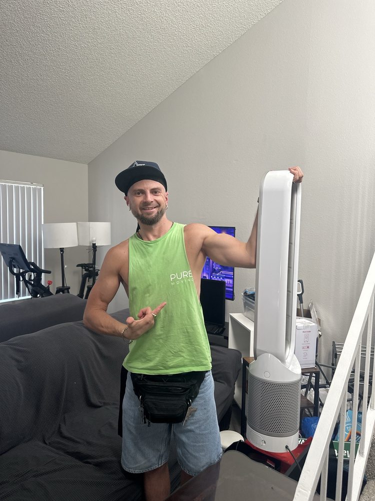Mover holding tall bladeless fan during apartment moving service