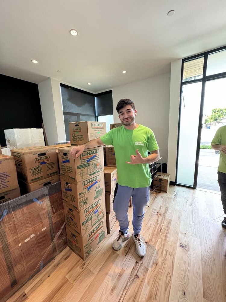 Mover holding tall bladeless fan during apartment moving service