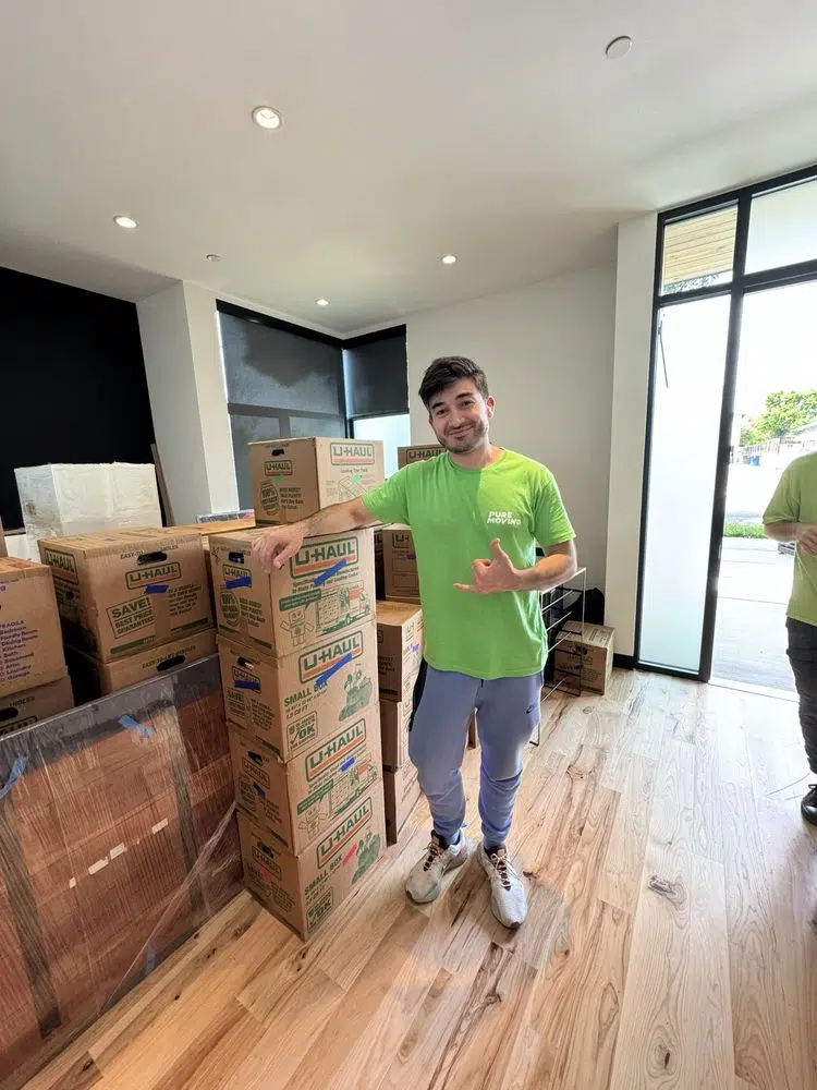 Mover holding tall bladeless fan during apartment moving service